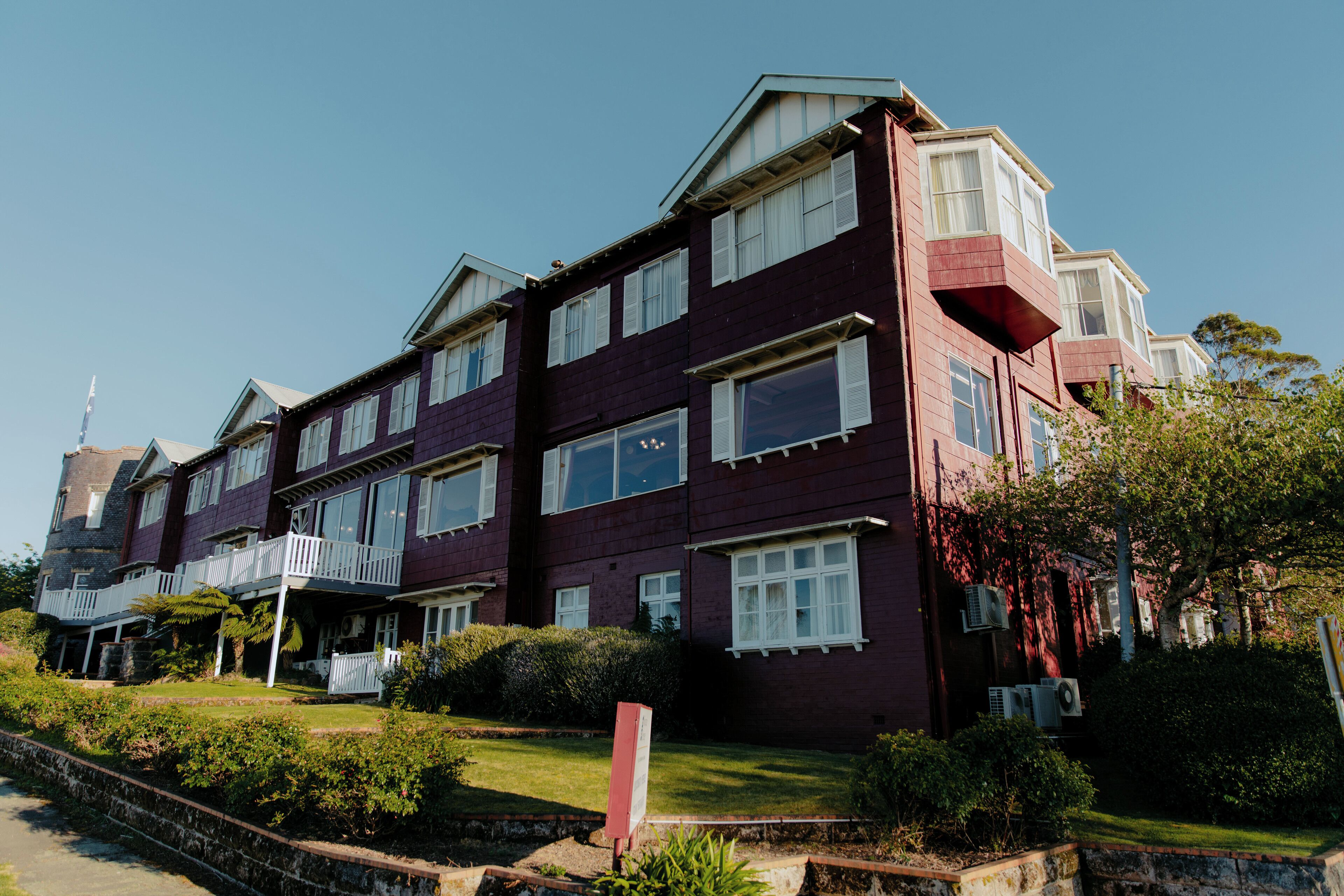 A multi-story building with a symmetrical facade, large windows, and a central entrance with a small porch.