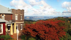 Un edificio histórico con fachada de ladrillo, entrada roja y vistas del paisaje circundante.