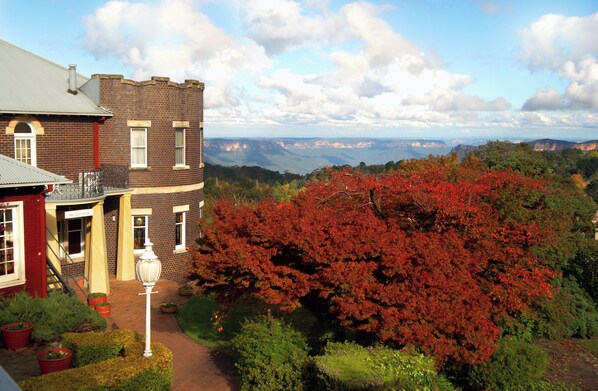 A historic building with a brick facade, a red entrance, and a view of the surrounding landscape.