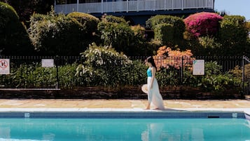 Una piscina al aire libre de temporada, sillones reclinables de piscina