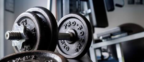 A gym with exercise equipment, including dumbbells and weight plates.