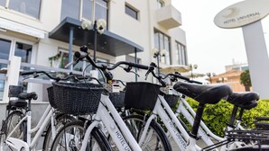 Varias bicicletas estacionadas frente a un edificio con un letrero que dice "HOTEL UNIVERSAL".
