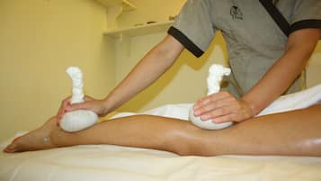 Seduta di massoterapia con una persona che utilizza un massaggio con pietra su una gamba.