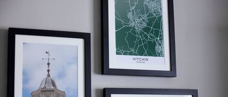 Tres cuadros: un veleta, un mapa de Hitchin, Inglaterra, y un paisaje con cielo azul.