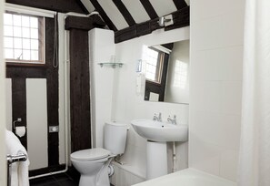 A bathroom with a toilet, sink, and shower.