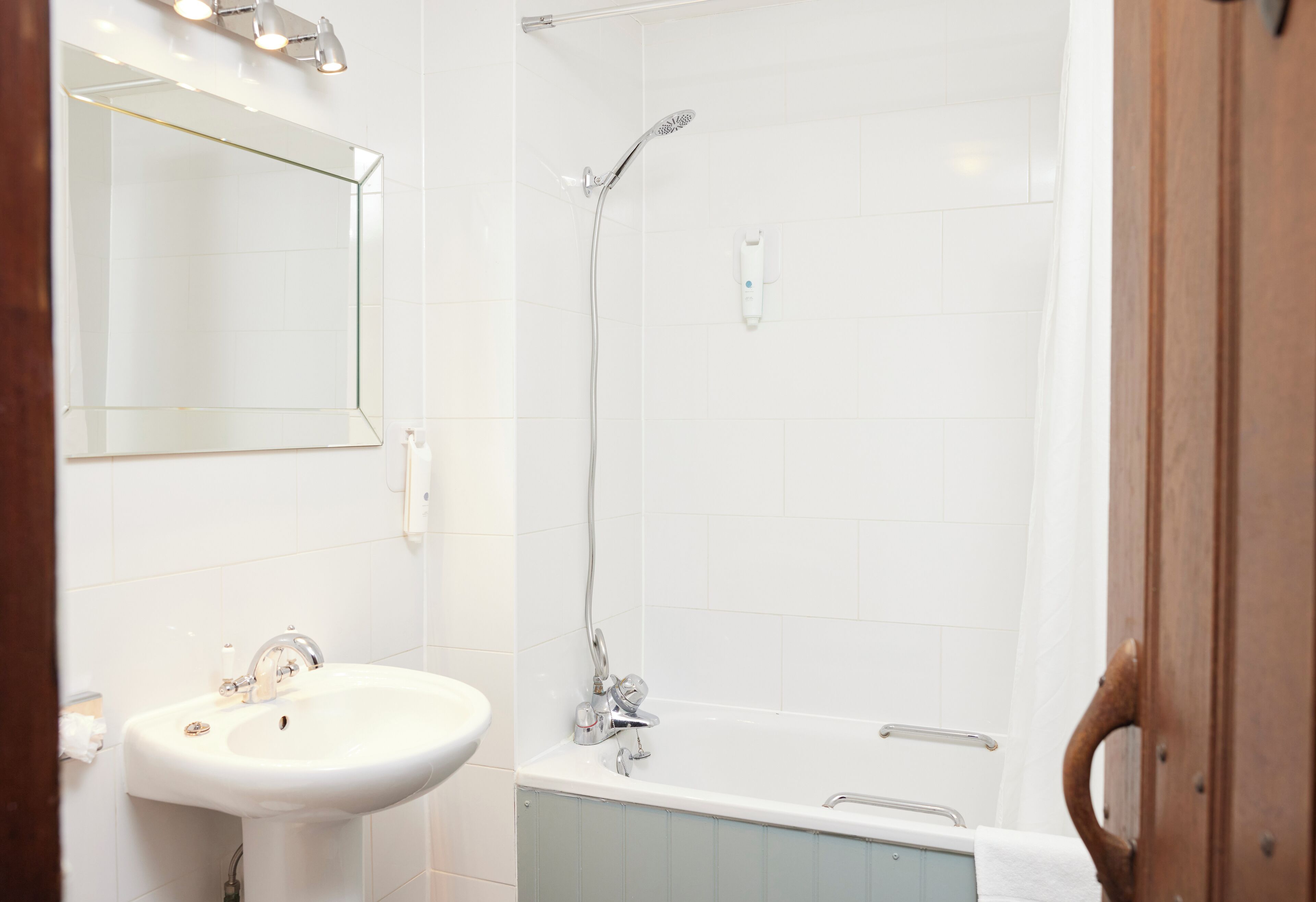 Un baño con lavamanos, espejo, ducha y bañera.