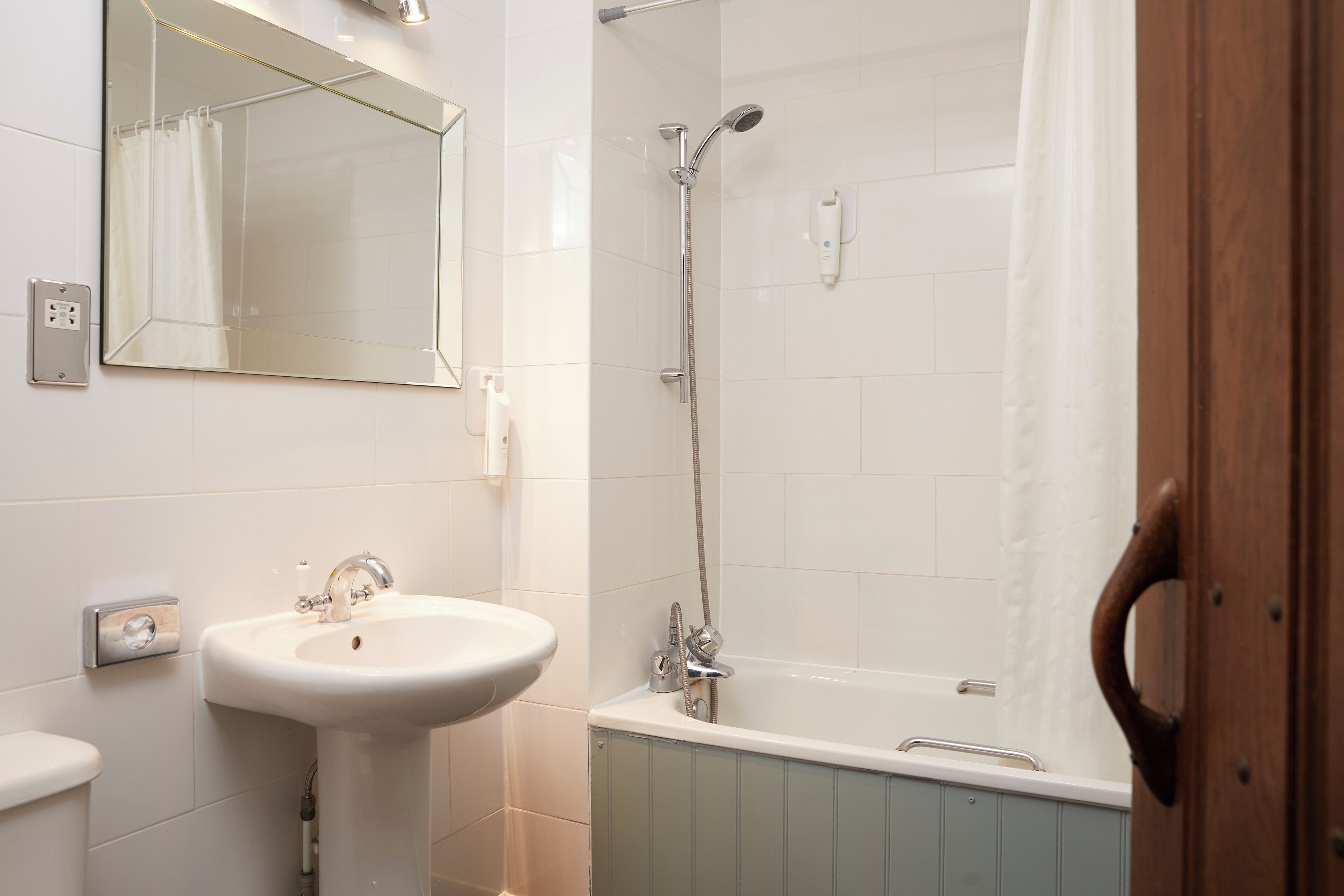 Une salle de bain équipée d’un lavabo, d’un miroir, d’une douche et d’une baignoire.