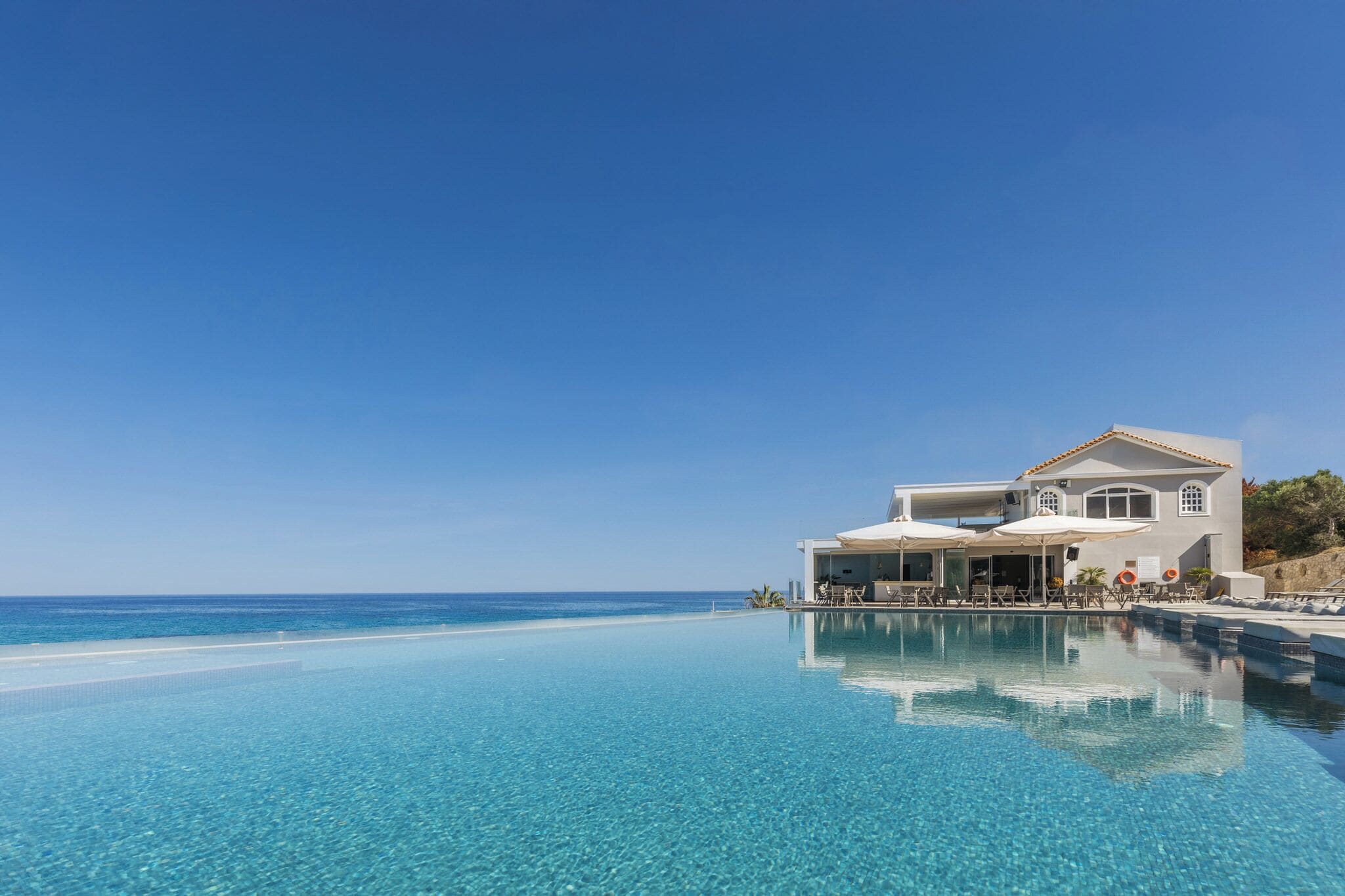 Een binnenzwembad, een buitenzwembad, parasols voor strand/zwembad
