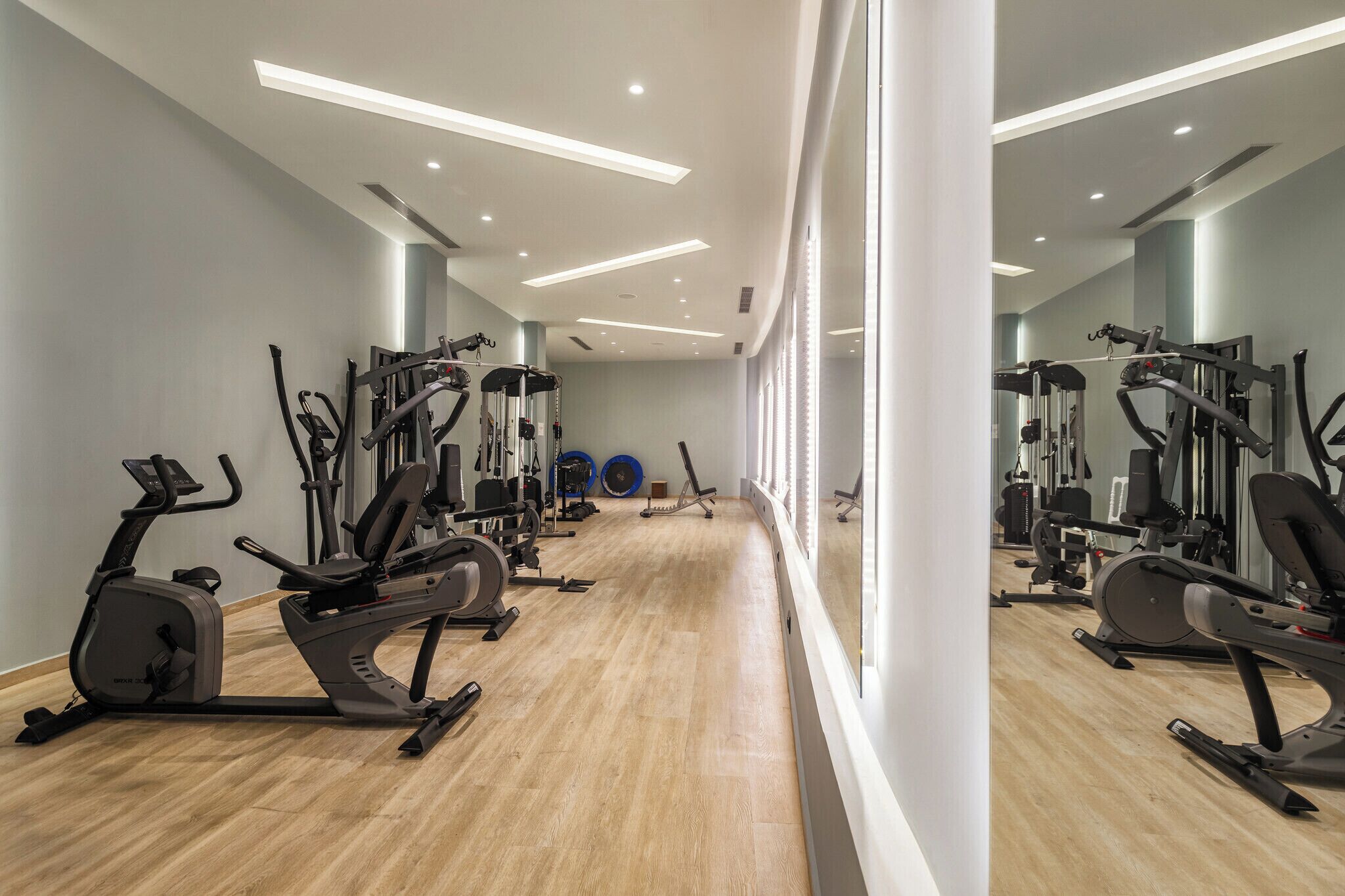 A gym with various exercise equipment, including treadmills, stationary bikes, and weight machines.