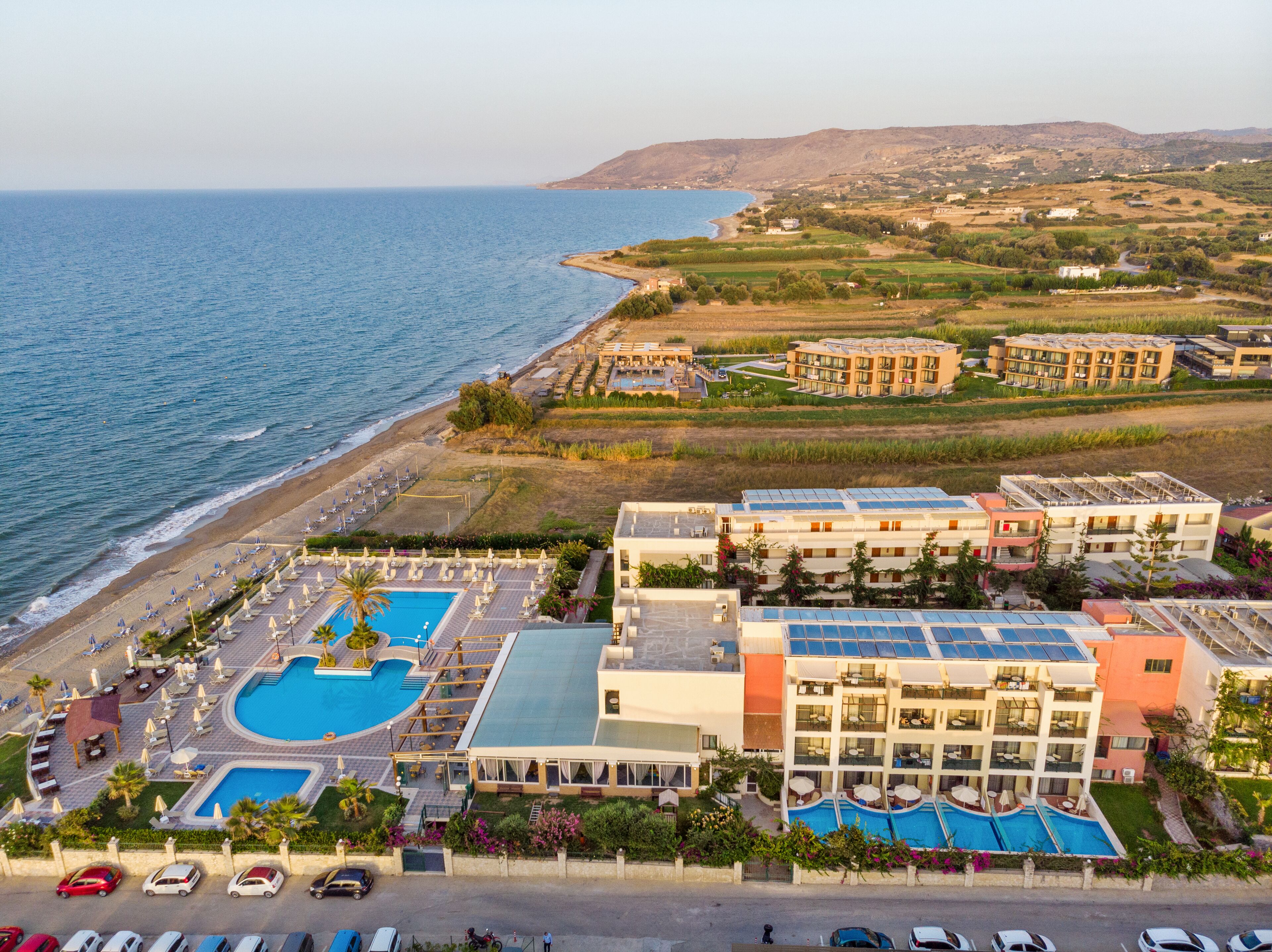A resort with multiple swimming pools, a beach, and a view of the sea.