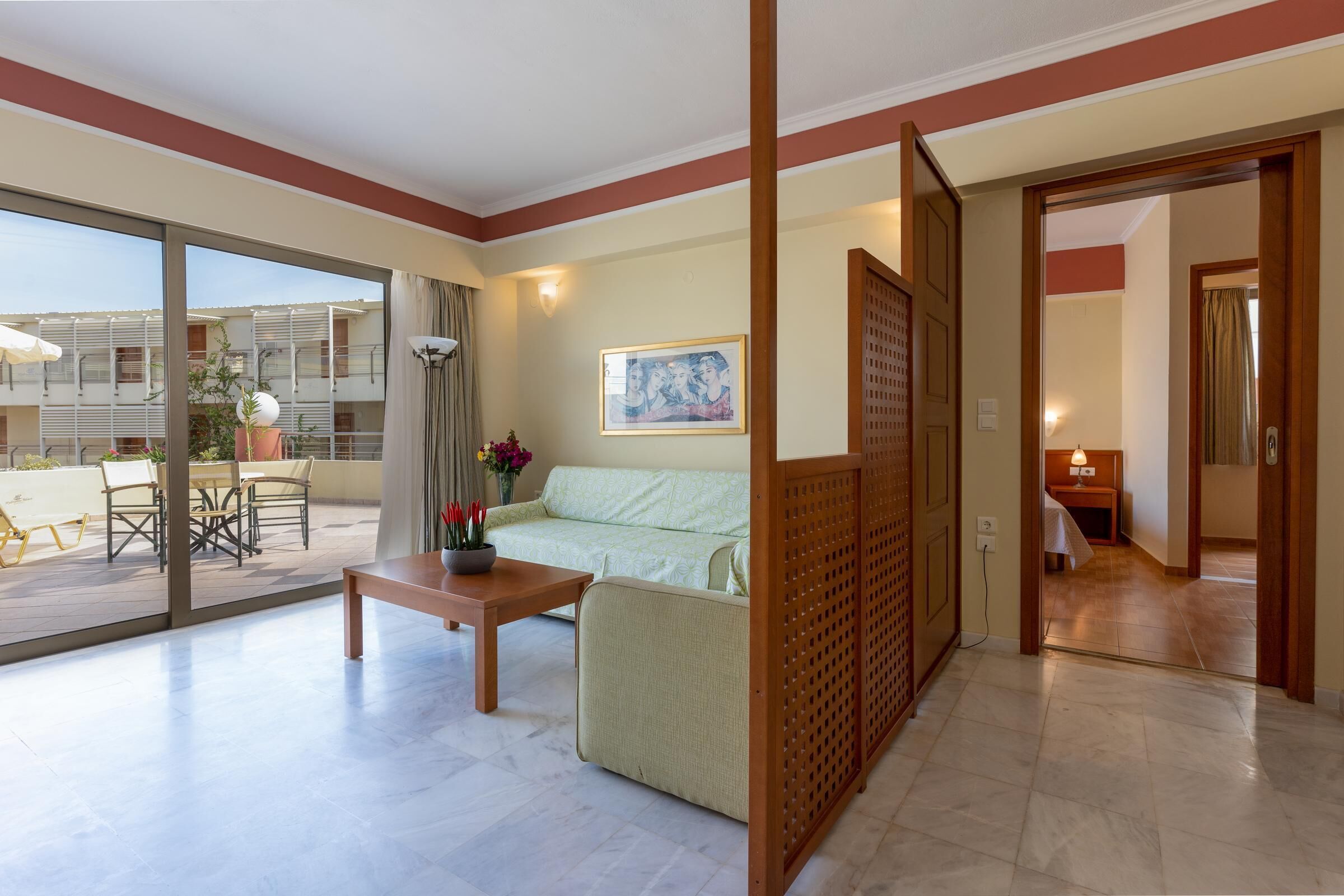 A spacious living area with a sofa, a coffee table, and a view of the outdoor balcony.