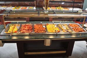 A buffet with various food items including meats, vegetables, and fruits. - Hydramis Palace Beach Resort (Apokoronas)