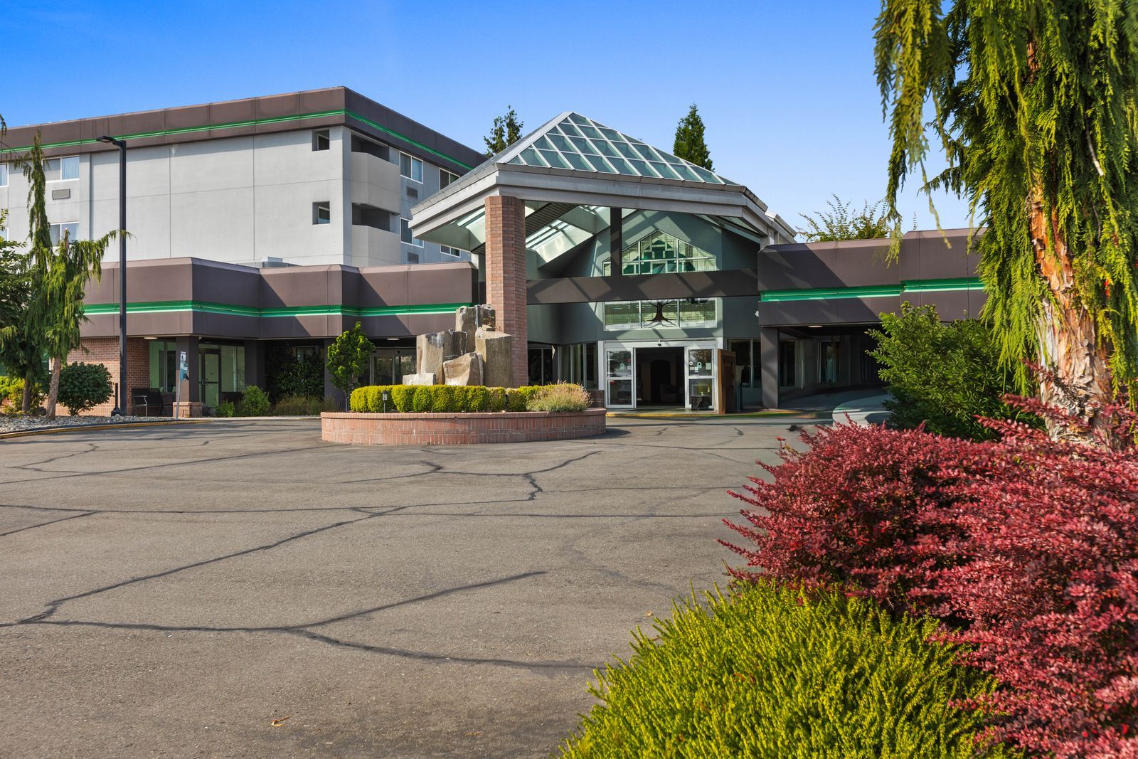 A modern building with a flat roof, large windows, and a central entrance with a glass canopy.