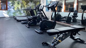 A gym with treadmills, elliptical machines, and weight equipment. - Medallion Inn & Suites (Arlington)