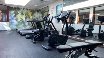 A gym with treadmills, elliptical machines, and weight equipment.
