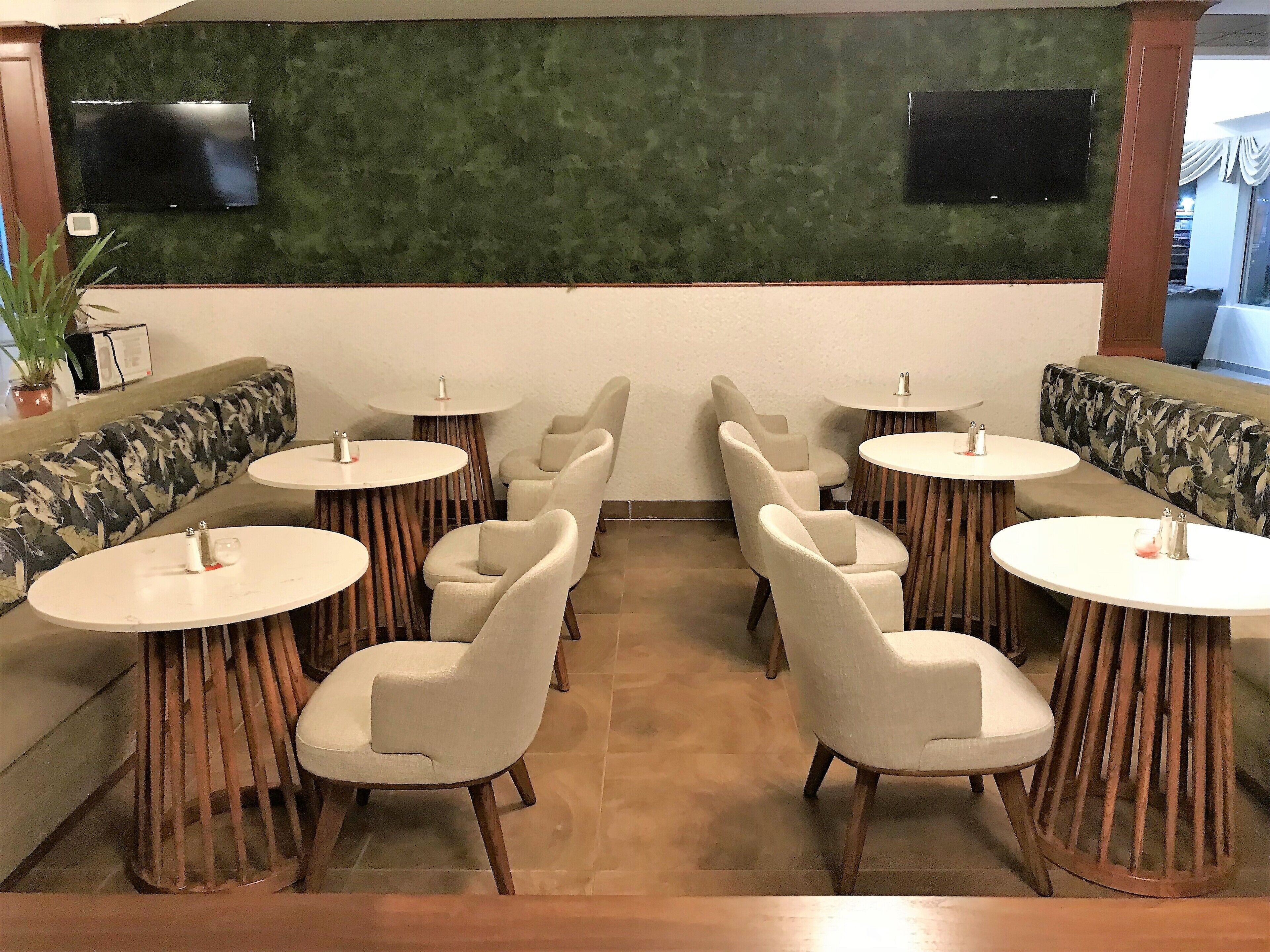 Een restaurant met ronde tafels en zachte zitplaatsen.