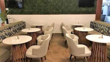 Een restaurant met ronde tafels en zachte zitplaatsen.