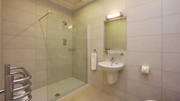 A modern bathroom with a glass-enclosed shower, a sink, and a toilet.