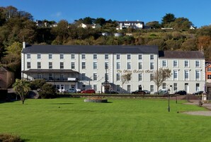 A large, multi-story hotel with a prominent entrance and a well-maintained lawn in front.