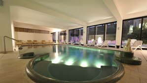 A large indoor swimming pool with lounge chairs and a statue. - Hotel Acquaviva del Garda (Desenzano del Garda)