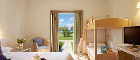 A hotel room with a bed, a desk with a TV, a bunk bed, and a view of the outdoors.