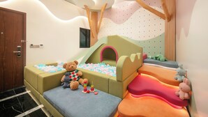 A children's play area with a ball pit, soft play structures, and a teddy bear. - Aurora Central Hotel  (Hanoi)