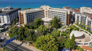 Un hotel con varios pisos, un patio central y vistas al mar.