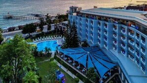 A hotel with a pool, outdoor seating, and a view of the sea. - Grand Kaptan Hotel - Ultra All Inclusive (Alanya)