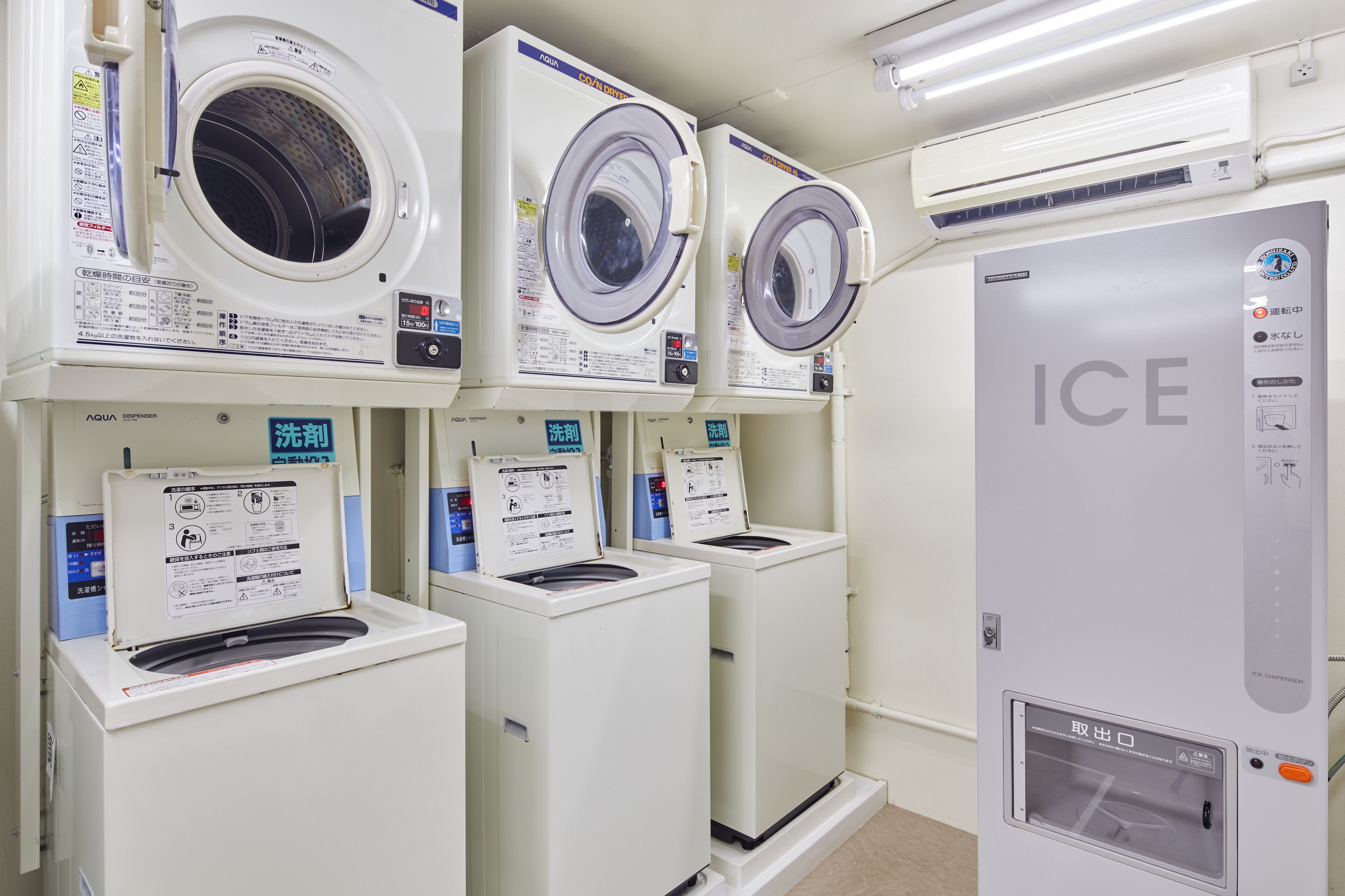 A row of front-loading washing machines with a control panel and a water dispenser.