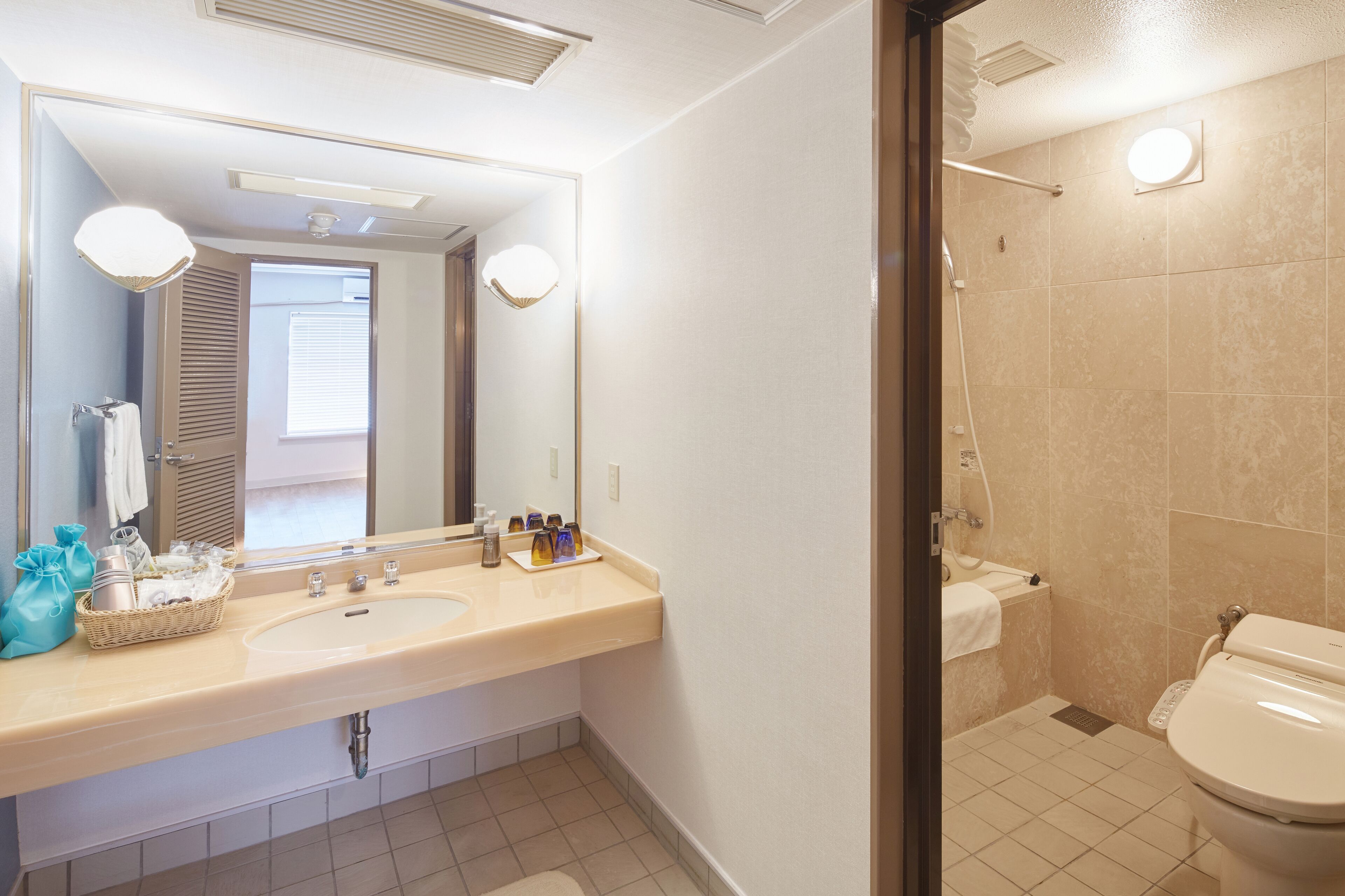 Un bagno con lavandino, specchio e water.