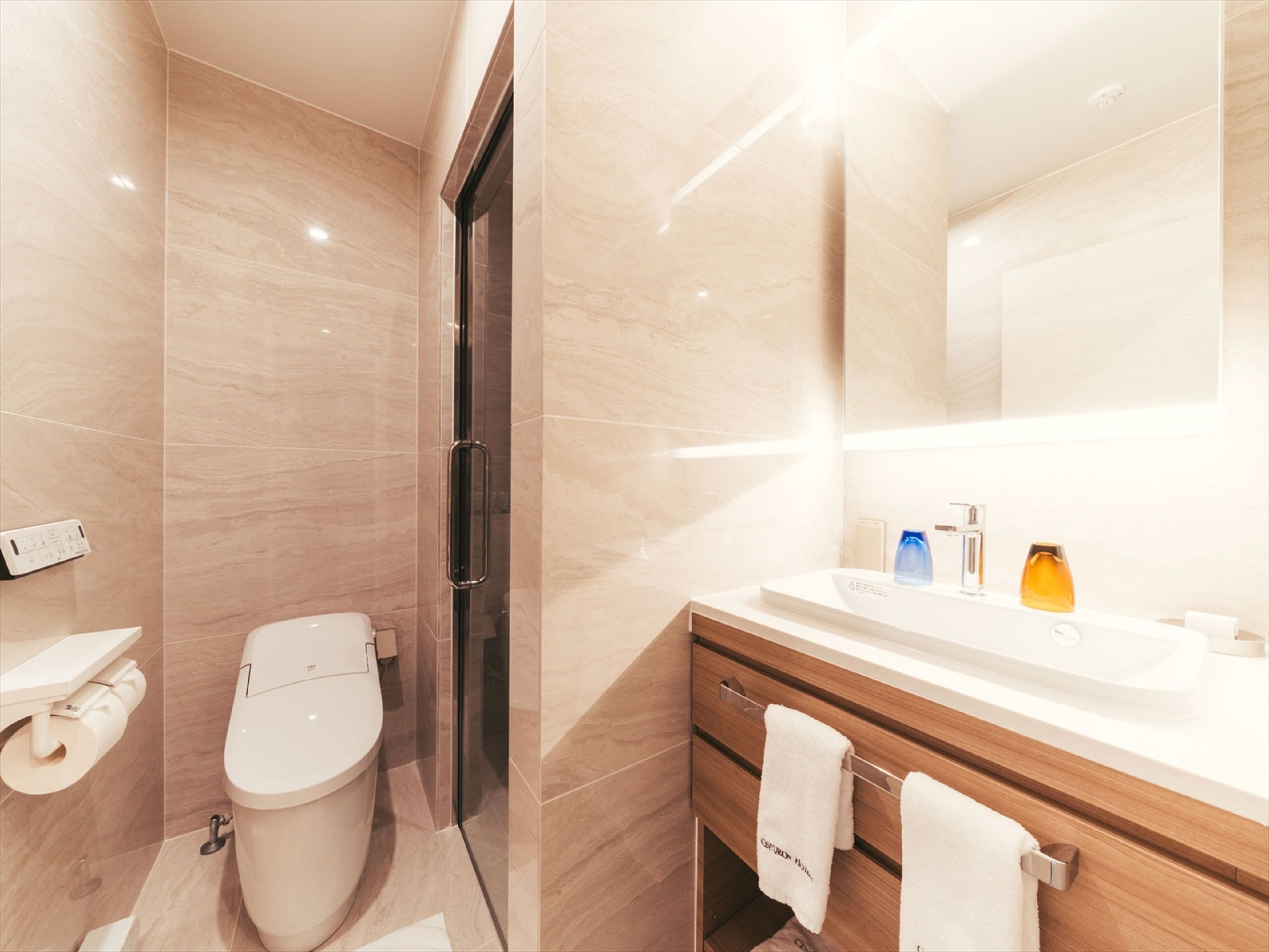A modern bathroom with a toilet, sink, and mirror.