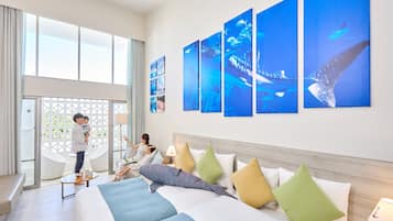 A hotel room with a large bed, a seating area, and a view of the outdoors.