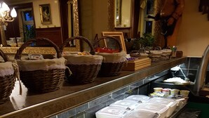 Een buffet met diverse etenswaren, waaronder fruit, groenten en zuivelproducten.