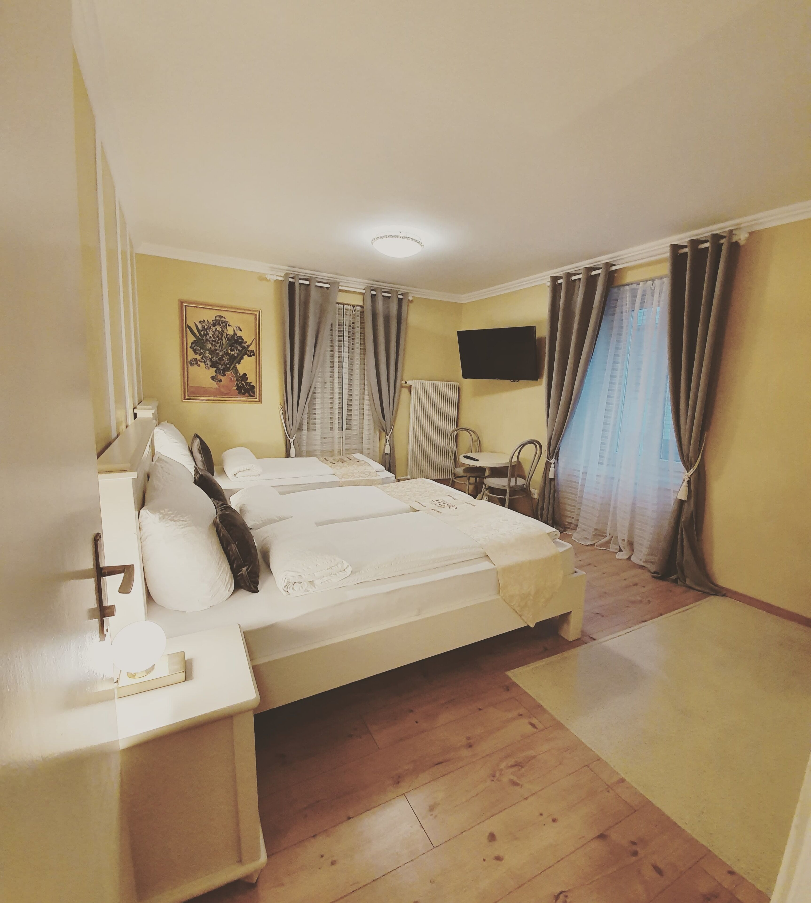 A hotel room with a bed, bedside table, lamp, chair, desk, and a TV.