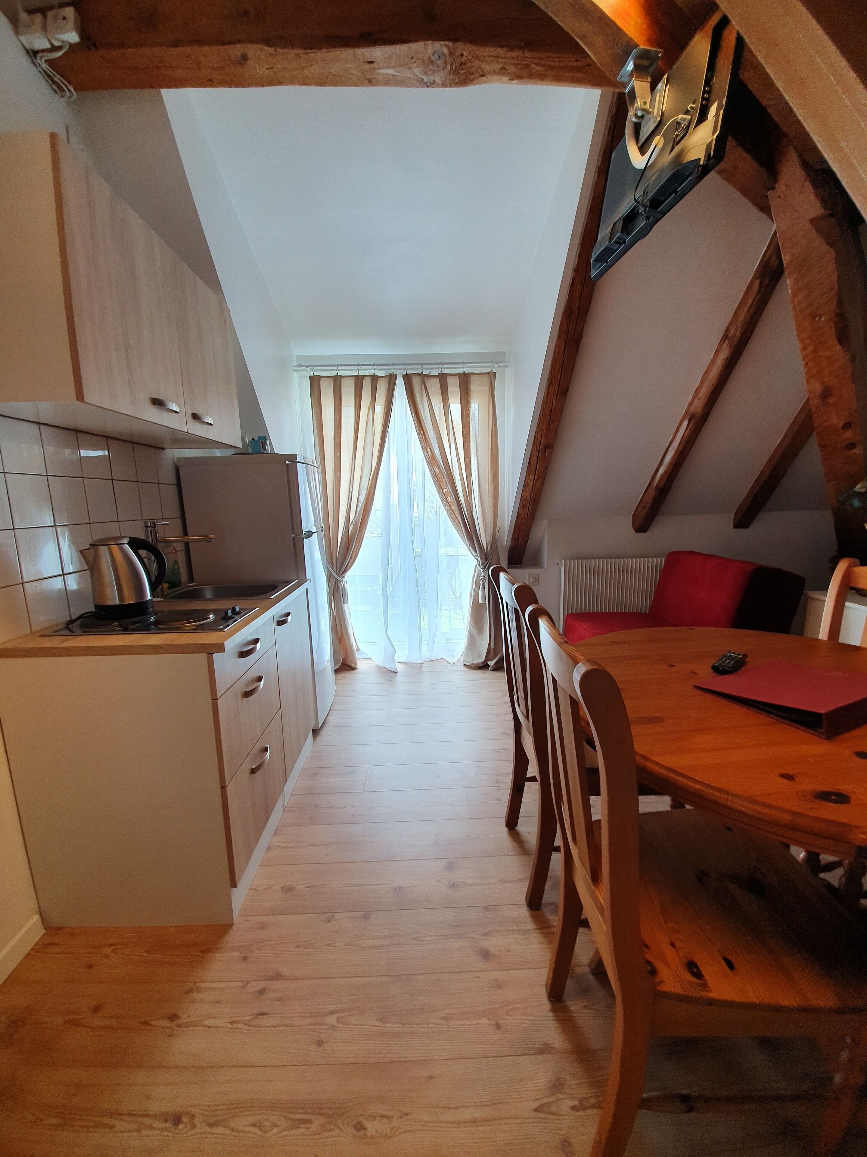 Una cocina con armarios de madera, una estufa y un comedor con mesa y sillas.