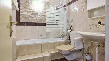 Une salle de bain moderne avec une baignoire, des toilettes et un lavabo.