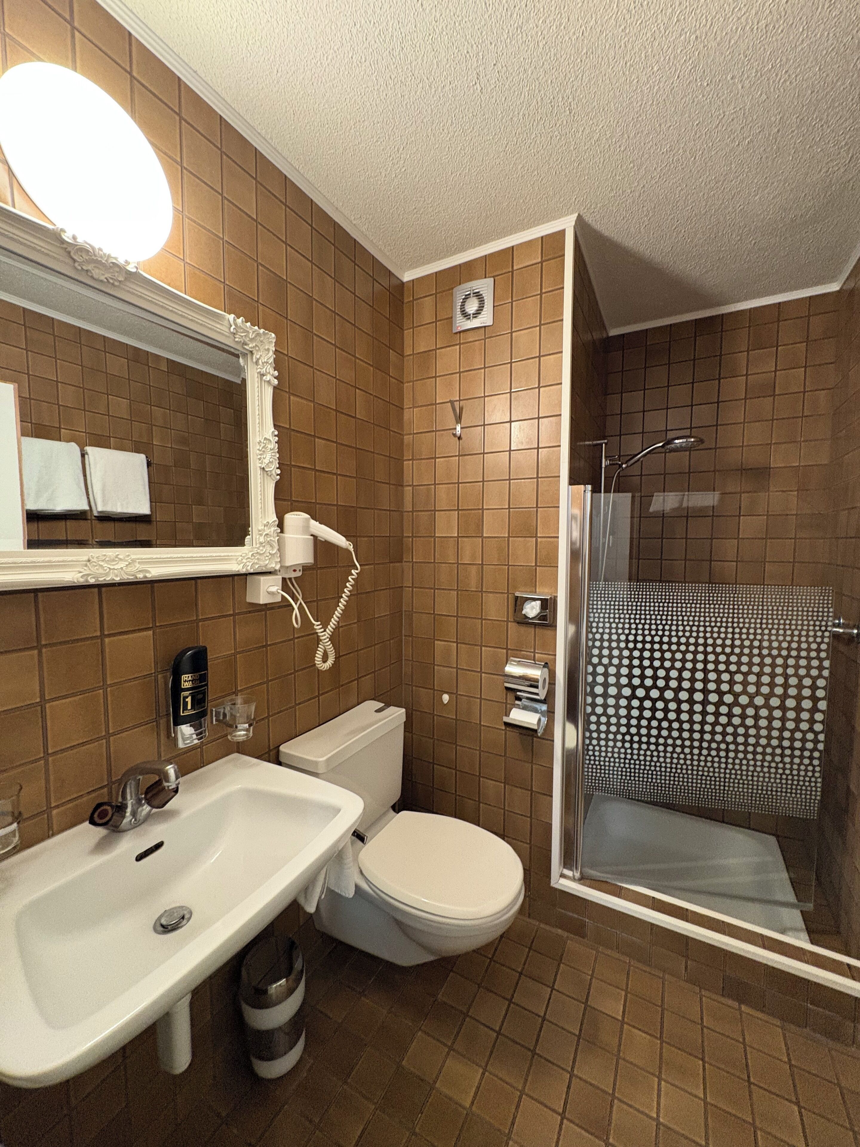 A bathroom with a sink, toilet, and shower.