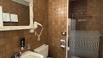 A bathroom with a sink, toilet, and shower.