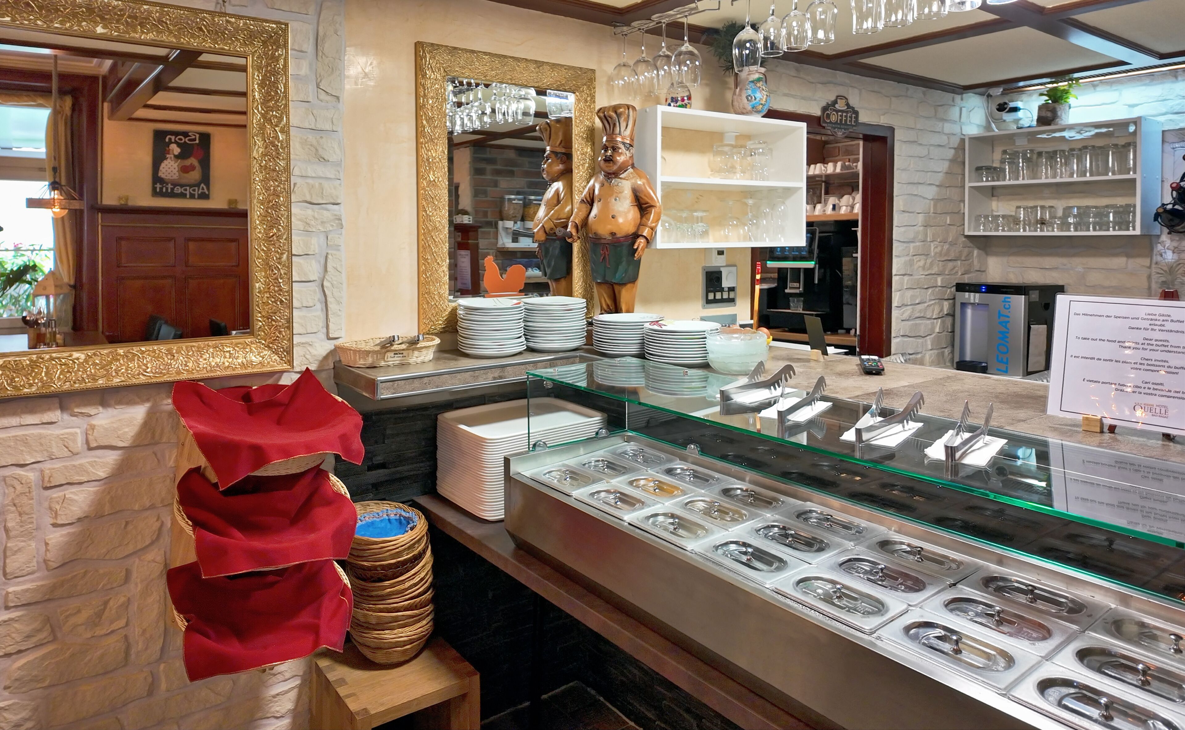 Een buffetgedeelte met diverse food stations, een spiegel en een koffiehoek.