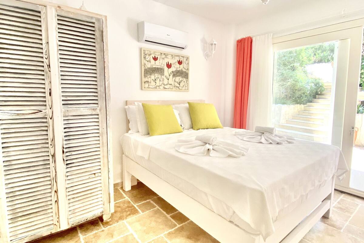 Un dormitorio con cama, armario, aire acondicionado y vistas al exterior.