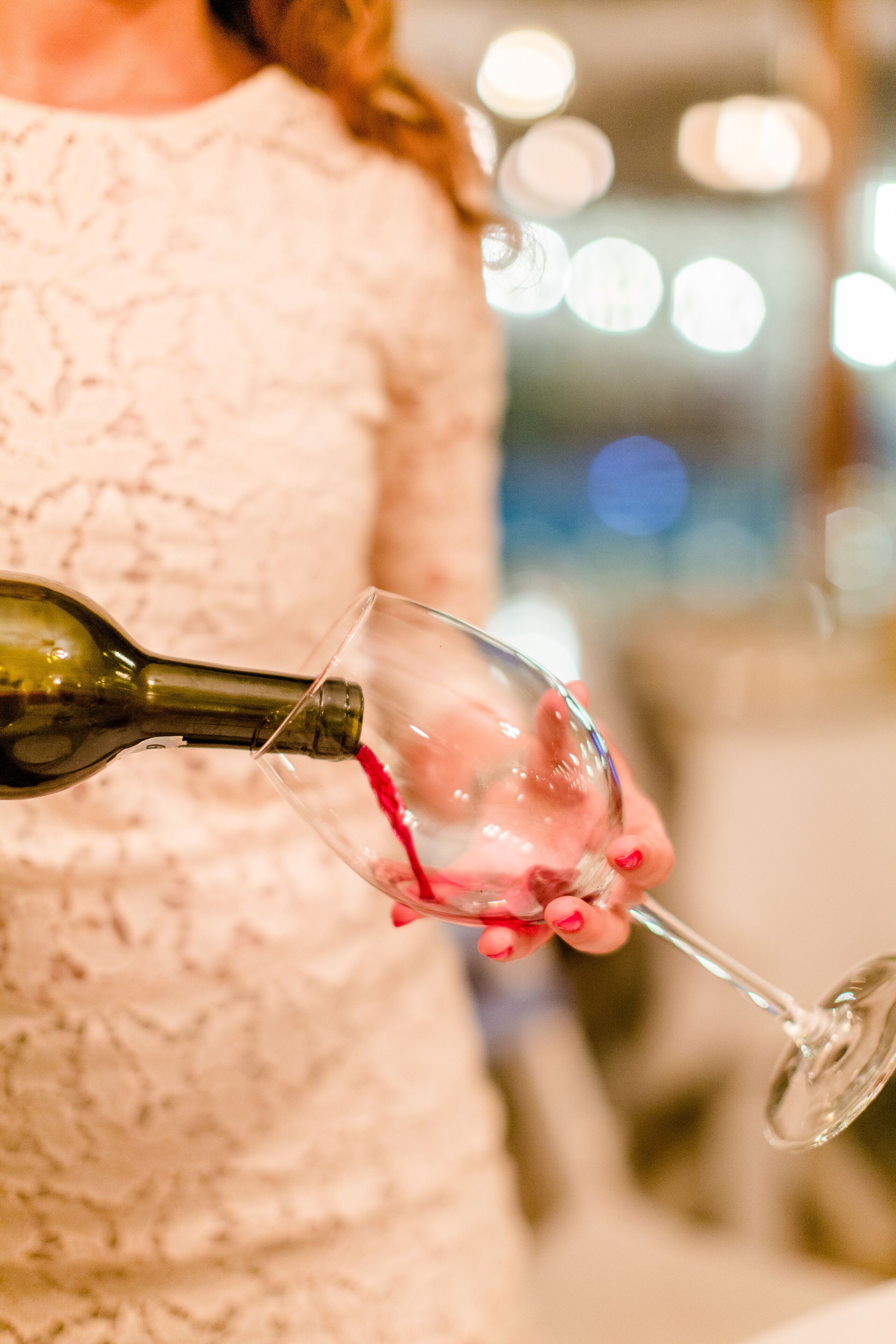 A person pouring wine into a glass.