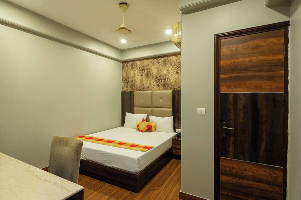 Una habitación de hotel con una cama, un escritorio y una puerta.