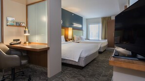 A hotel room with a desk, two beds, a TV, and a large mirror. - SpringHill Suites by Marriott Columbia Downtown/The Vista (Columbia)