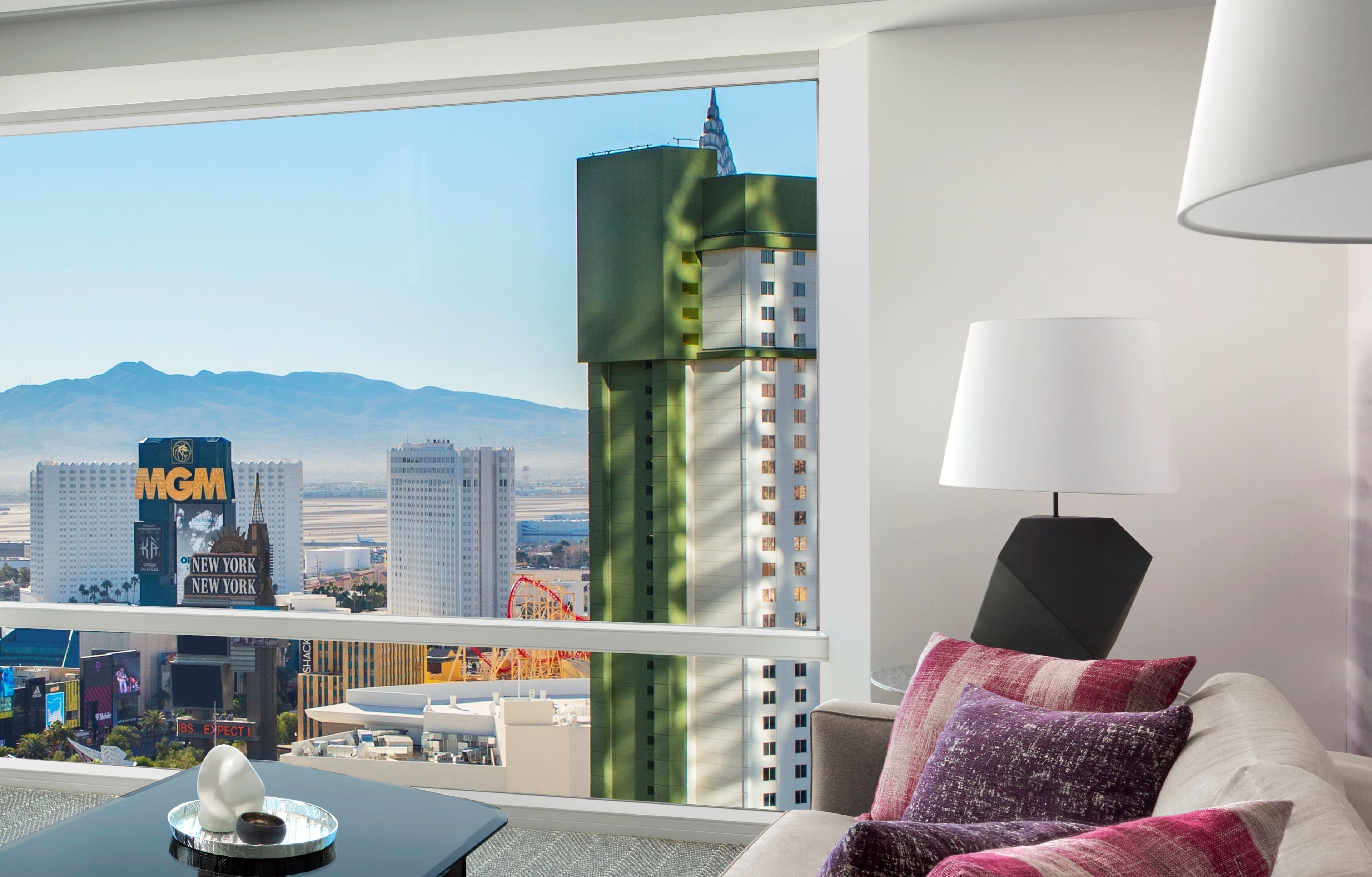 A hotel room with a view of the MGM building and other Las Vegas landmarks.