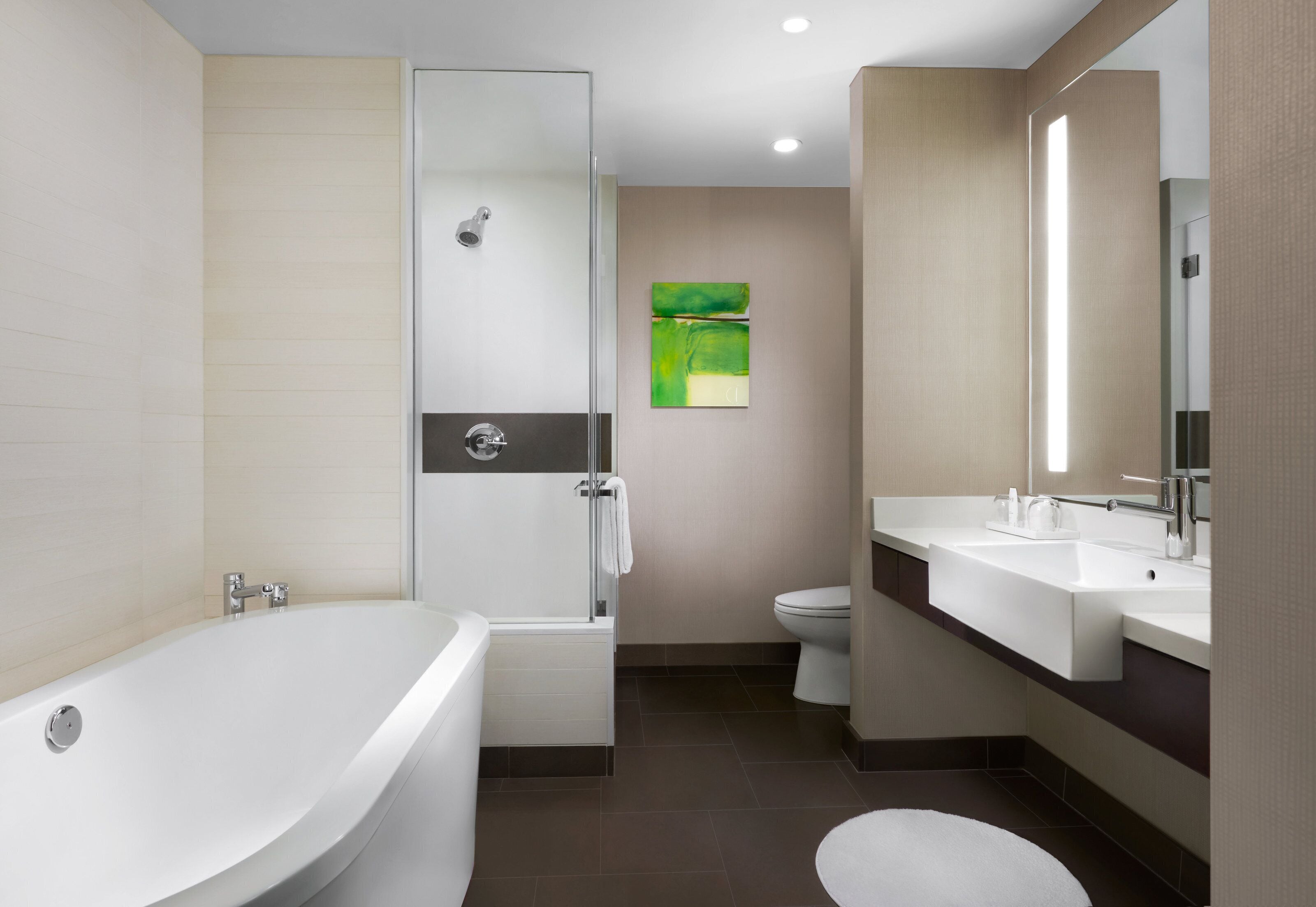 A modern bathroom with a freestanding bathtub, a glass-enclosed shower, a toilet, and a sink with a mirror.