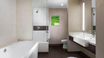 A modern bathroom with a freestanding bathtub, a glass-enclosed shower, a toilet, and a sink with a mirror.