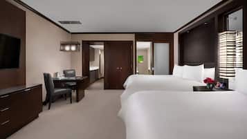 Habitación de hotel con cama, escritorio, televisión y baño.