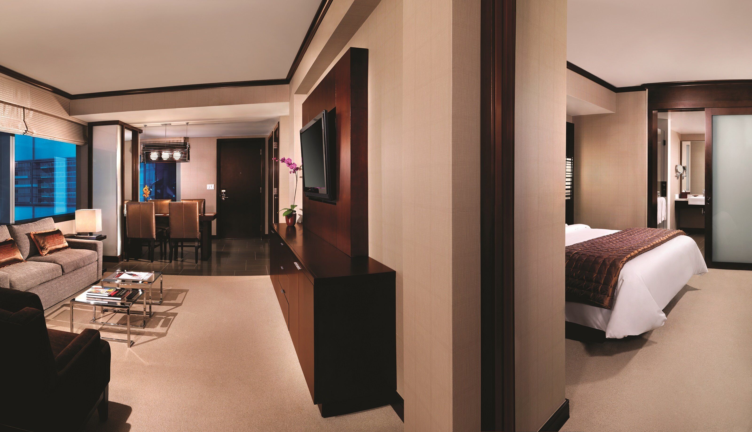Ein Hotelzimmer mit Bett, einer Couch, einem Couchtisch, einem Fernseher und einem Schreibtisch.