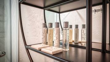A bathroom shelf with various toiletries, including bottles and soap bars.