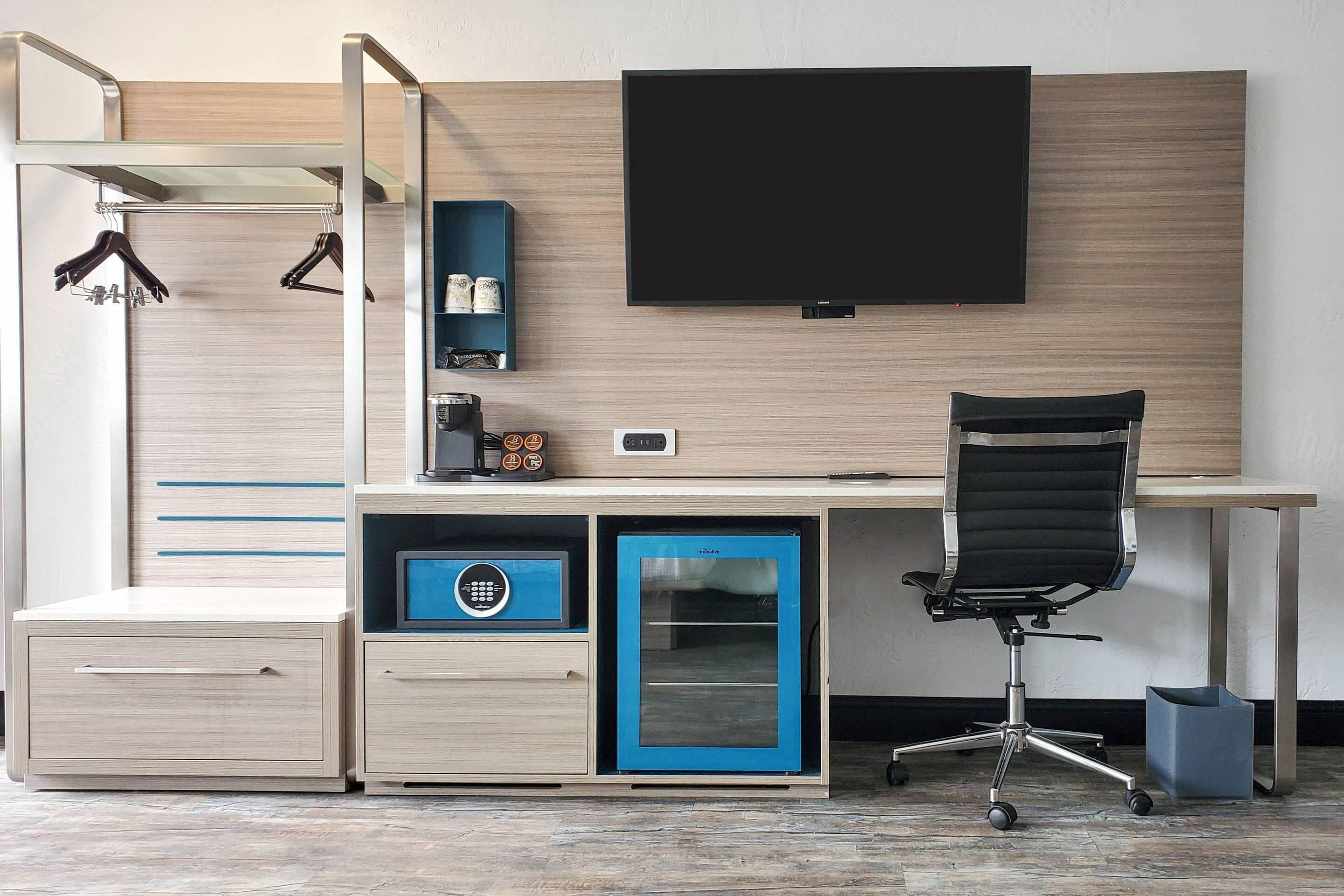 A modern office space with a desk, chair, and built-in storage.